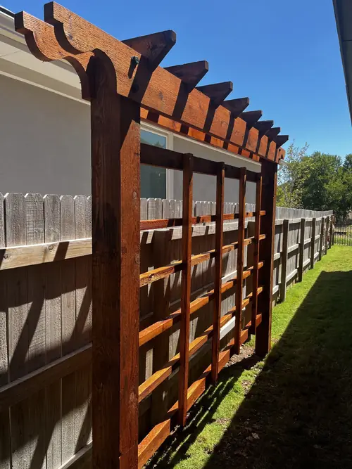 Cedar arbour with lattice panels shading a side-yard wall